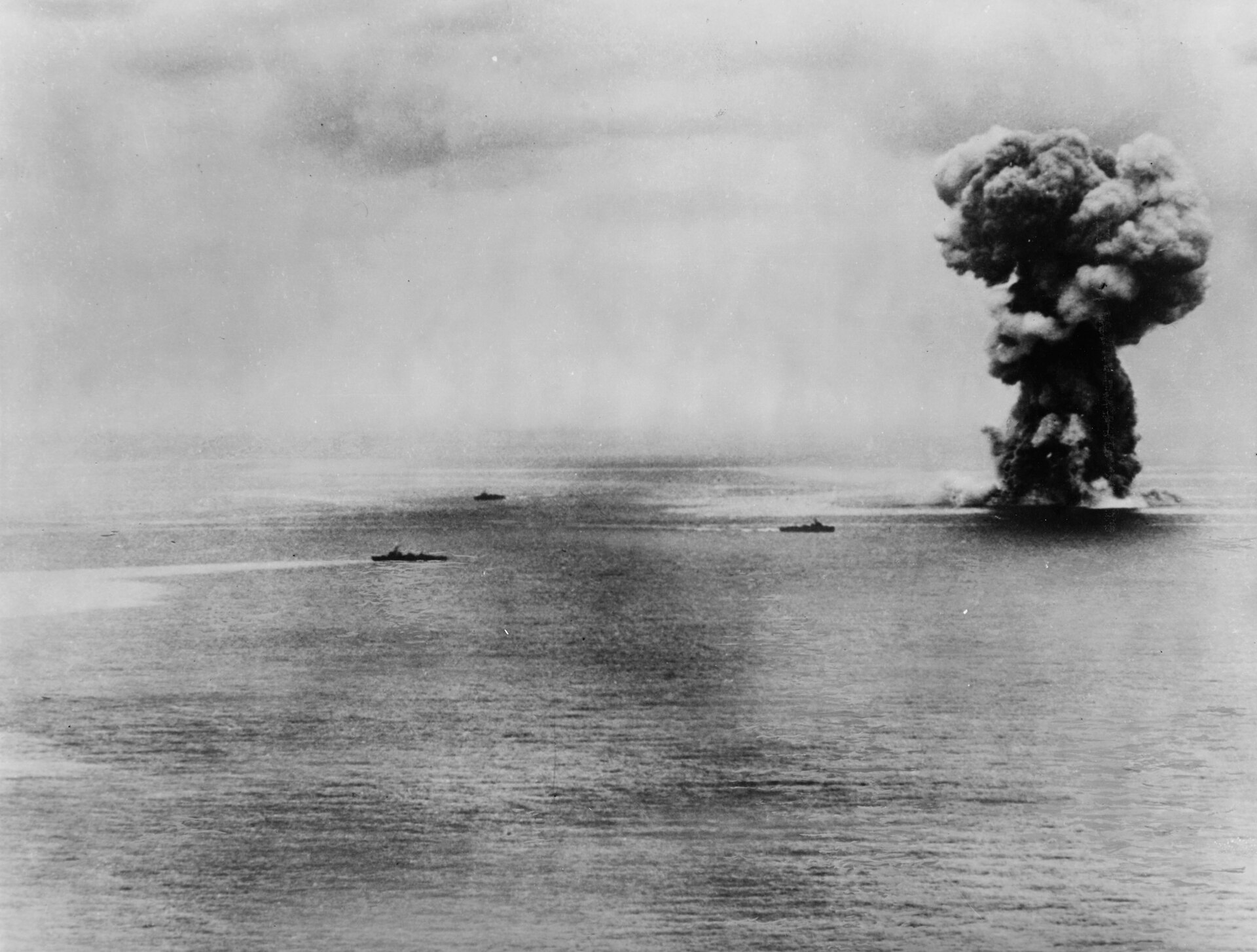 Massive mushroom cloud explosion rising from the ocean surface.